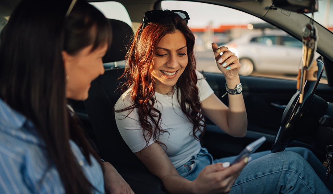 Teen sharing phone in car getting help for anxiety.