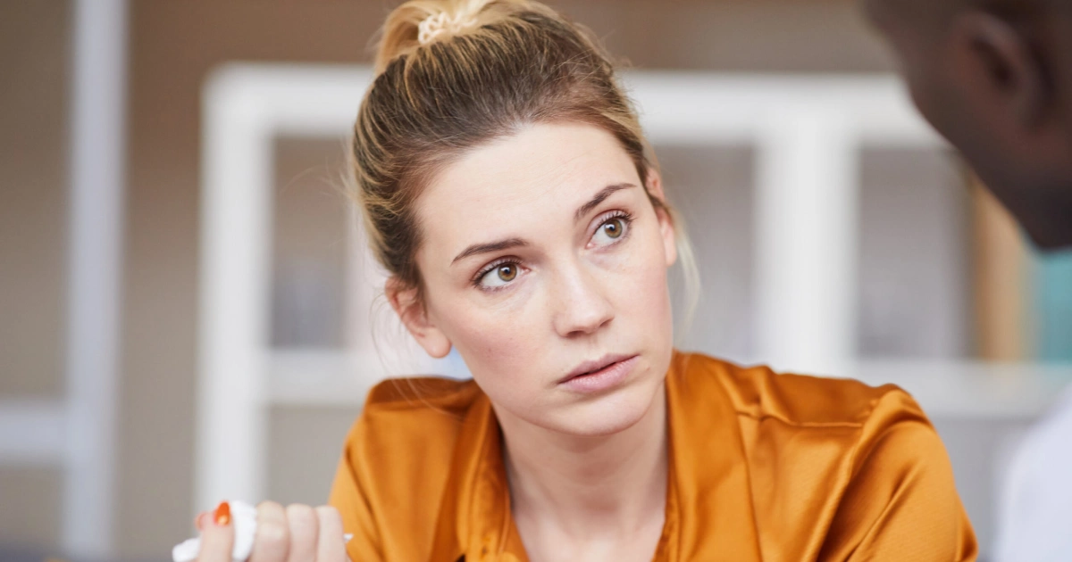 Woman listening intently during a serious conversation.