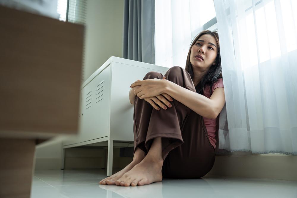 Asian young upset depressed woman sitting alone