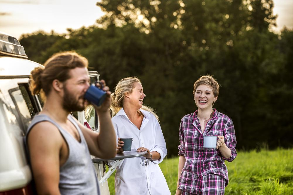 Carefree friends enjoying coffee at a van