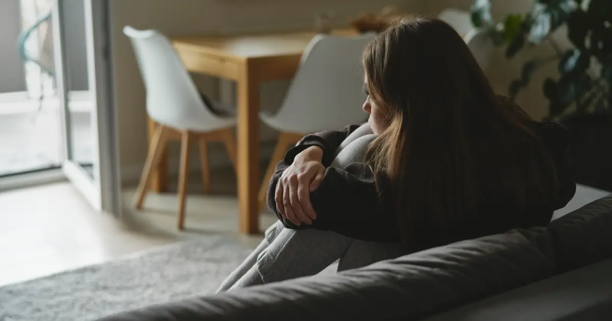 Caucasian sad woman sitting at the sofa