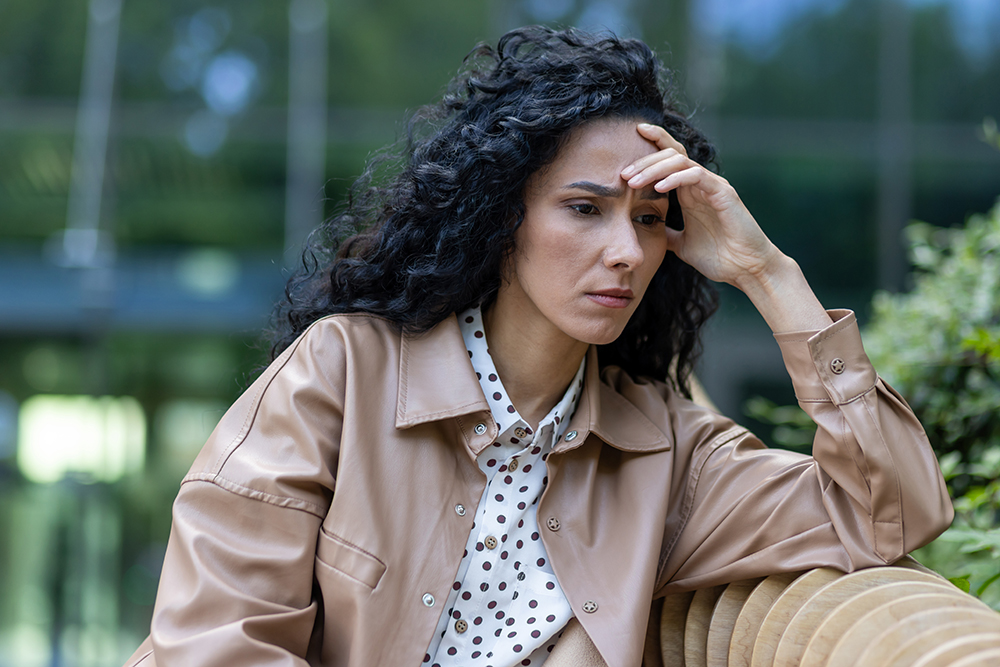 Depressed mature adult woman sitting on bench